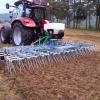 Grass harrow fitted with a seeder